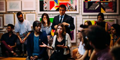 Woman talking to group of people around artwork