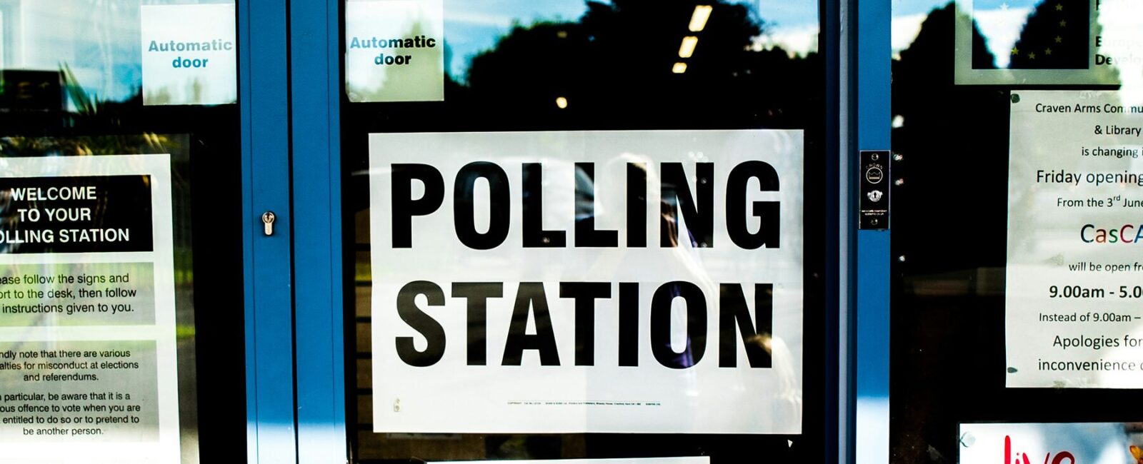 Polling station poster on clear glass door