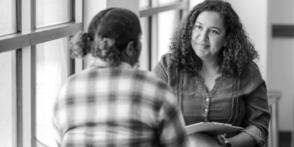 Two women in casual clothing having a discussion. One is a adviser, listening intently.