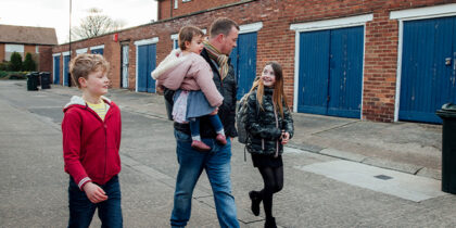A father and children walking in street