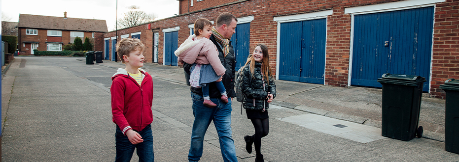 A father and children walking in street