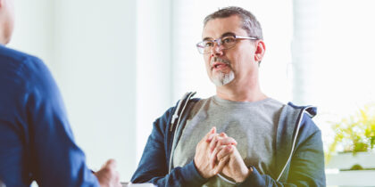 Two men in conversation in a bright airy room
