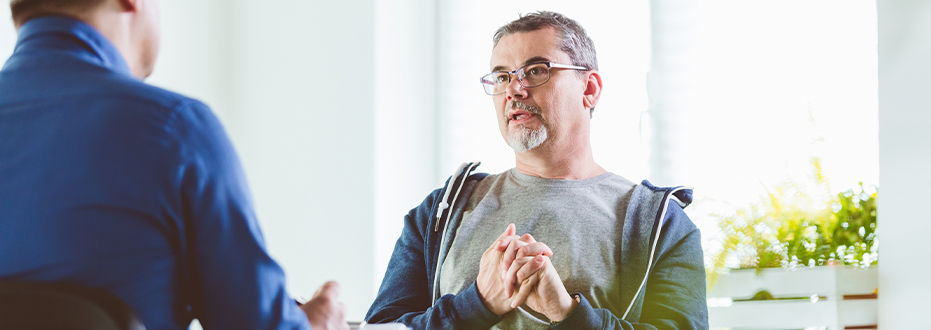 Two men in conversation in a bright airy room