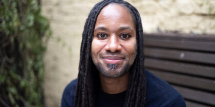 Photo of a young Black man, Jason Arday, smiling into the camera