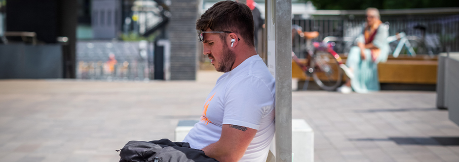 A man sitting in the shade on a hot day