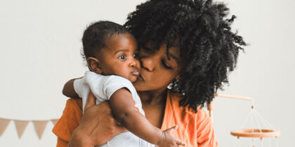 A Black mother cradling a baby
