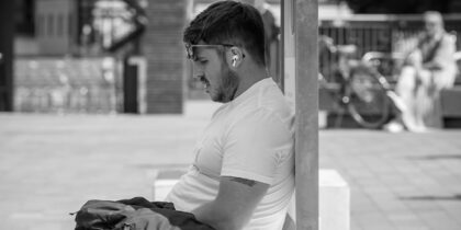 A man sitting in the shade on aq hot day