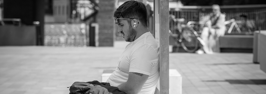A man sitting in the shade on aq hot day